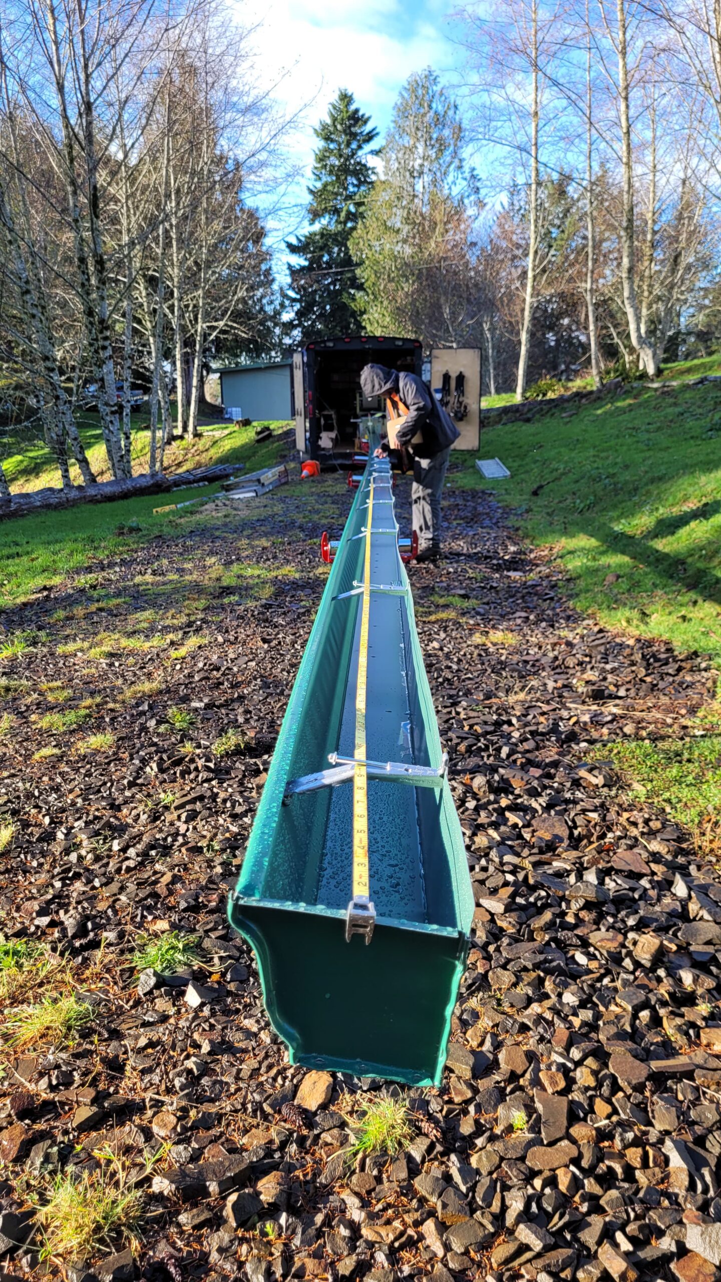 Brothers Gutters team fabricating seamless gutters on-site in Oregon